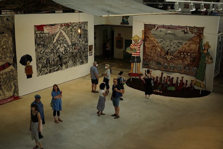 Art as a Catalyst for Social Change in the MENA Region Suzi Fadel Nassif, contemporary artist, posing with one of her vibrant, surrealist paintings.